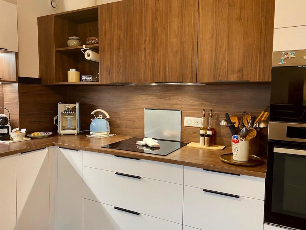 a kitchen with wooden cabinets and a counter top at "Maison Bleue" Quartier Haut,Clim,Parking,Jardin in Sète