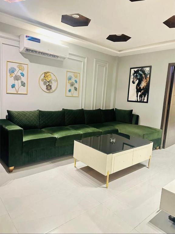a living room with a green couch and a coffee table at Apartment in Bahria Town Lahore in Lahore