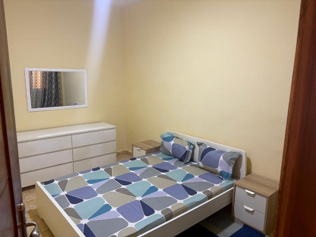 a bedroom with a bed with a blue and white pattern at Ouest foire in Dakan
