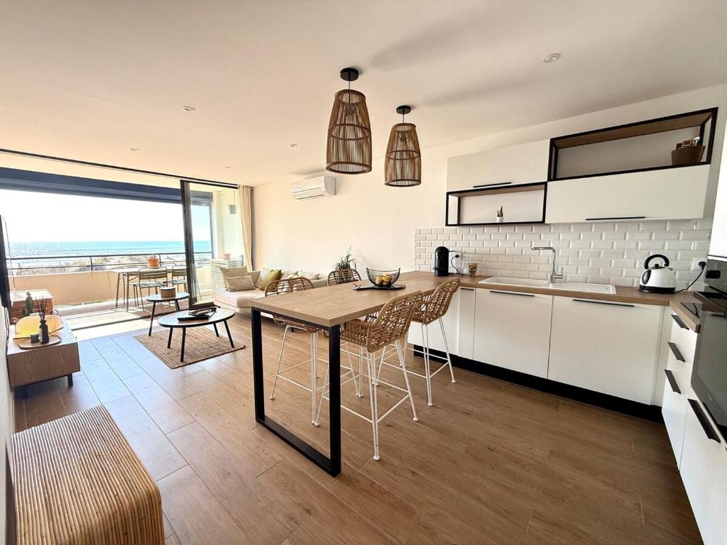 une cuisine et un salon avec une table et des chaises dans l'établissement Appt bord de mer,Clim & parking, à La Grande Motte