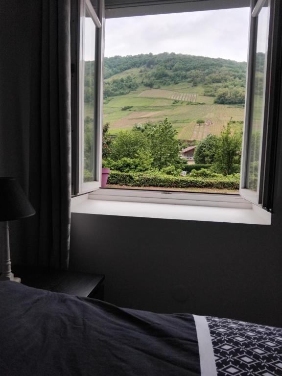 - une chambre avec une fenêtre offrant une vue sur la montagne dans l'établissement Le petit cocon, à Cerdon