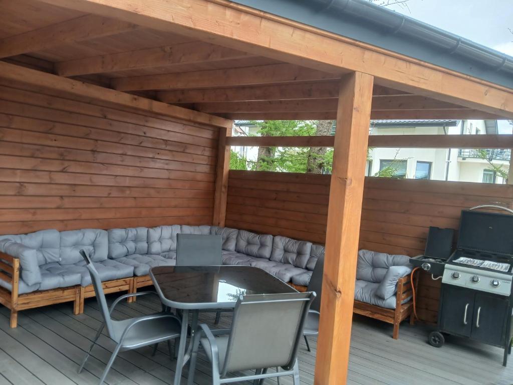 a patio with a couch and a table and a grill at Wakacyjny dom in Karwia
