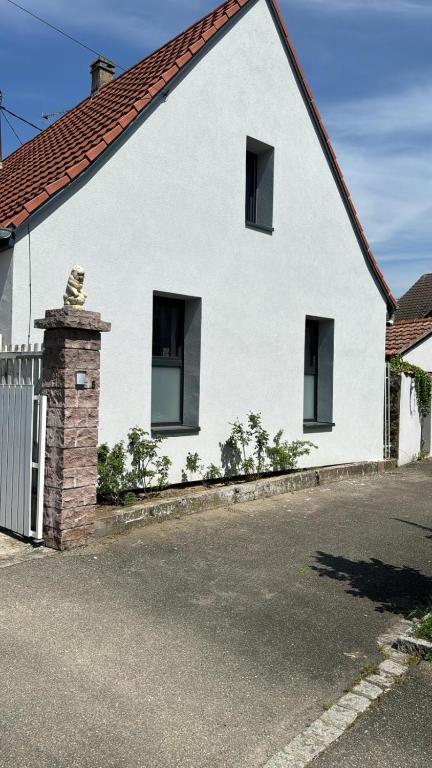 une maison blanche avec un toit rouge dans l'établissement House La Belle Escapade, à Sainte-Croix-en-Plaine