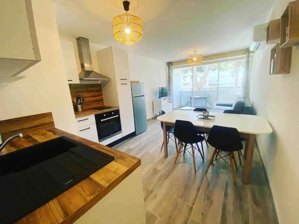 une cuisine et une salle à manger avec une table et des chaises dans l'établissement Appartement 37m2, parking, wifi, clim, centre-ville port, à La Grande Motte