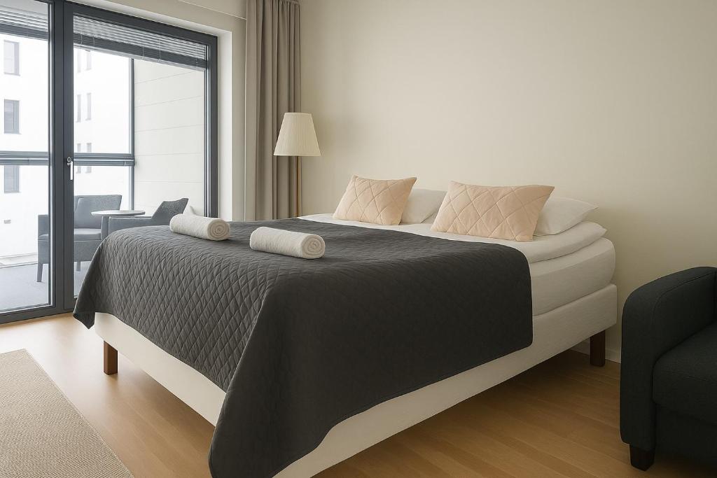 a bedroom with a large bed with a large window at City Home Finland Big Luxury Suite - Spacious Suite with Own SAUNA, One Bedroom and Furnished Balcony next to Train Station in Tampere