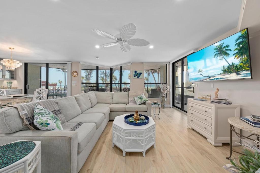 a living room with a couch and a flat screen tv at Pine Cove 104 in Sanibel