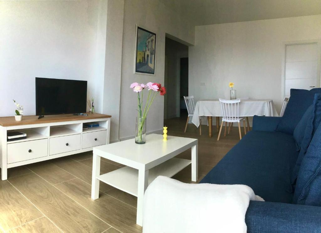 a living room with a blue couch and a table with a tv at Huerta Nueva 2º Izquierda in Santa Cruz de la Palma