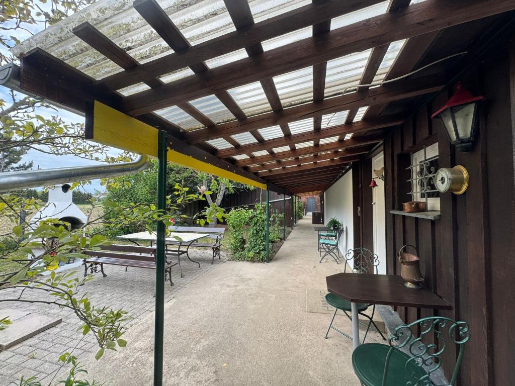 a patio with a wooden pergola and a table and chairs at Matilda III - Naturidyll mit Komfort in Mirow