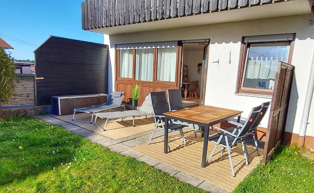 a patio with a table and chairs next to a house at Ferienwohnung am Bichl - Stilvoll mit Terrasse, Carport und Gästekarte in Lechbruck