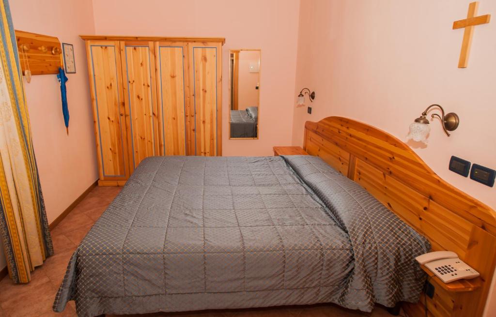 a bedroom with a bed and a cross on the wall at Hotel Vittoria in Riva del Garda