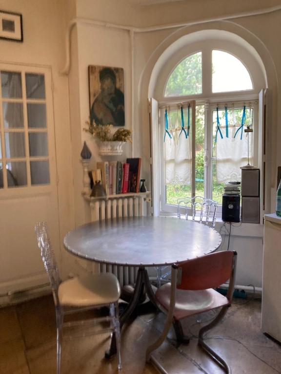 une salle à manger avec une table et des chaises et une fenêtre dans l'établissement Suite Panthéon-Hôtel Particulier Historique du 17e, à Paris