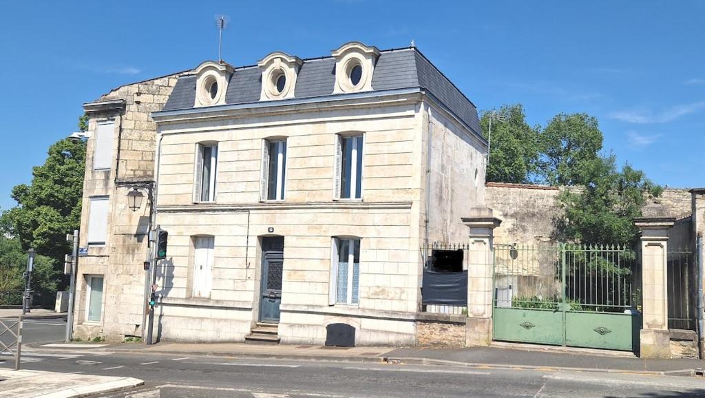 - un vieux bâtiment en pierre au coin d'une rue dans l'établissement F3 original Maison bourgeoise Port Boinot, à Niort