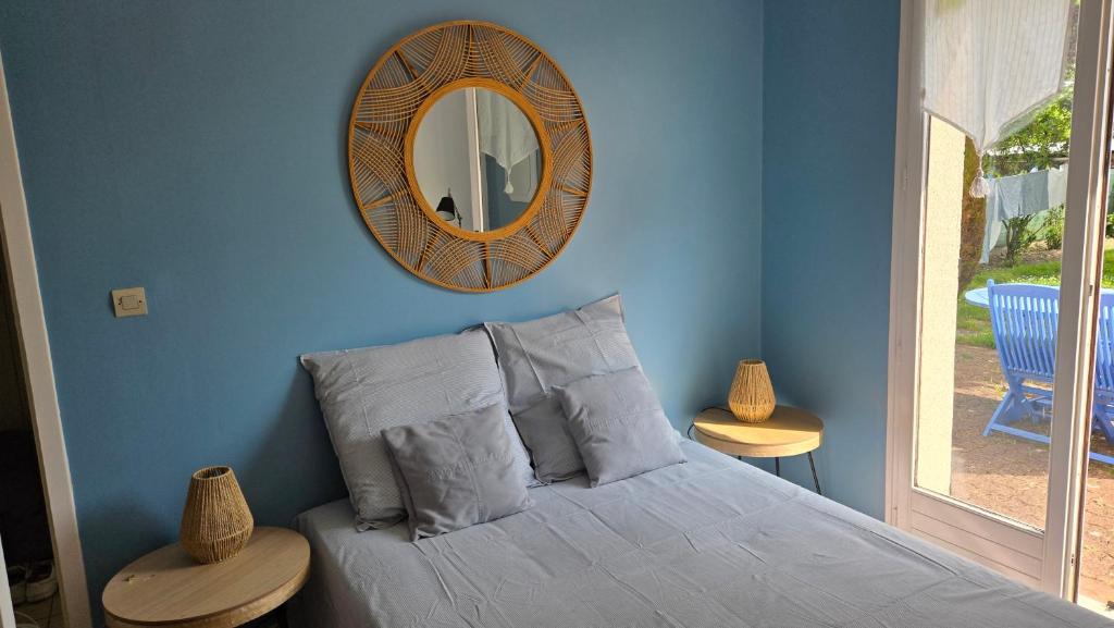 une chambre avec un lit avec un miroir au mur dans l'établissement Le Bleuet de Montbazon, à Montbazon