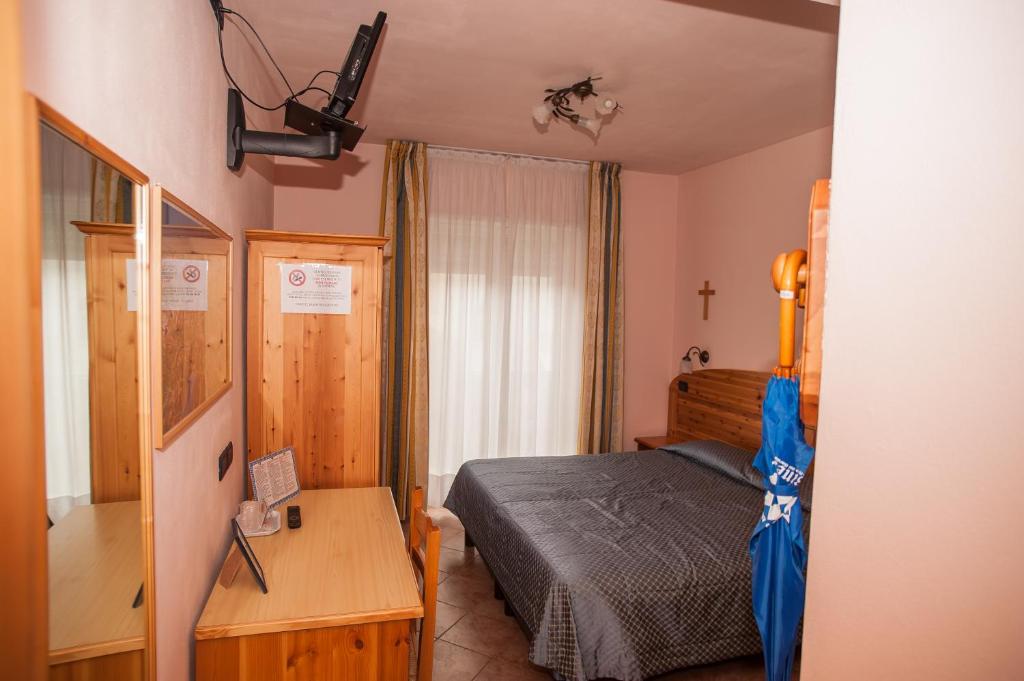 a bedroom with a bed and a blue umbrella at Hotel Vittoria in Riva del Garda