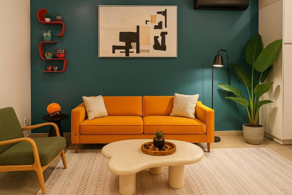 a living room with an orange couch and a table at King Suite | North Shore | Gigabit Internet in Chattanooga