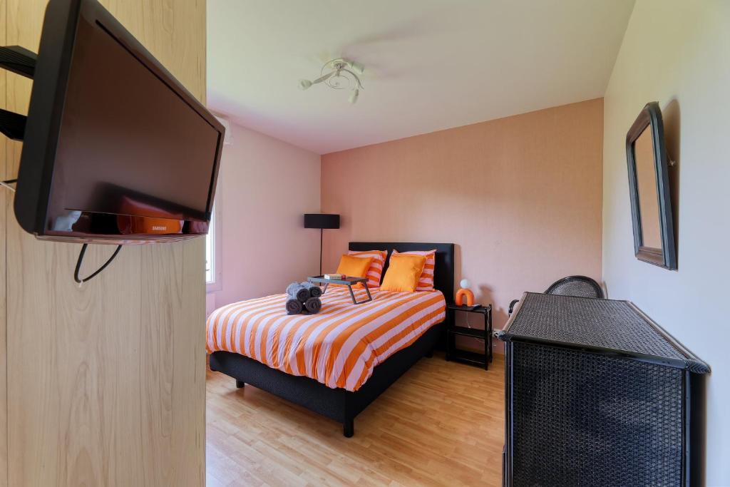 une chambre avec un lit et une télévision à écran plat dans l'établissement Les rives de la Sèvre, à Vertou