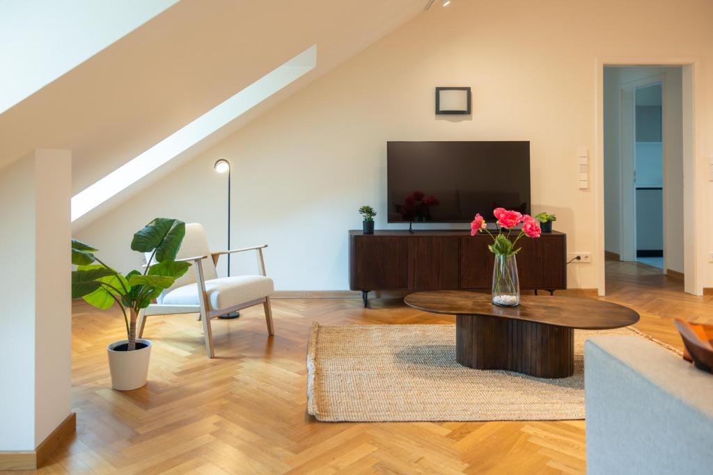 a living room with a table and a tv at Grand Rue Residence 1 Bedroom Apartment in Luxembourg