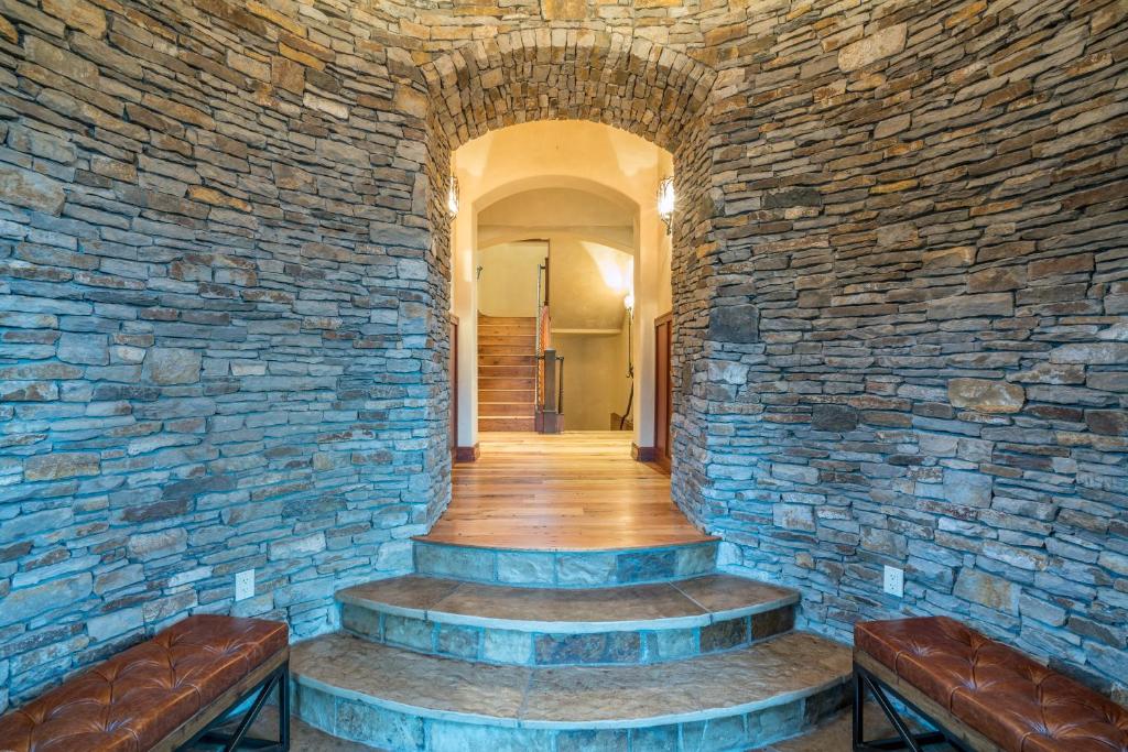a stone hallway with two benches and a stone wall at Two Trails by Exceptional Stays in Telluride