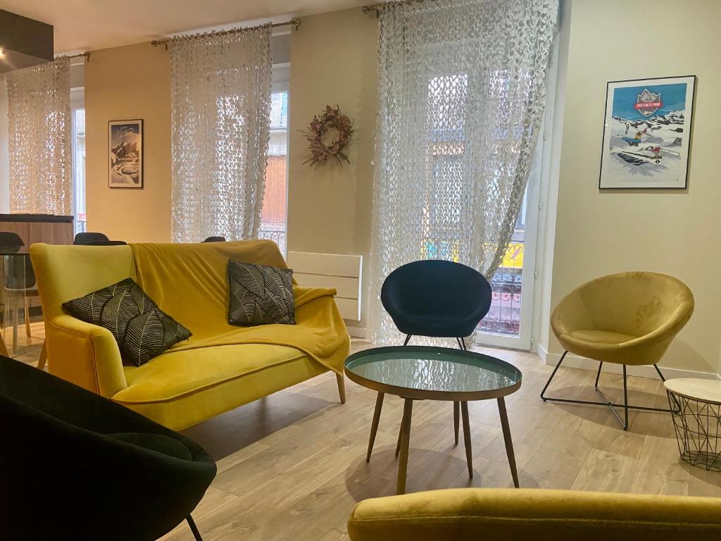 - un salon avec un canapé jaune et deux chaises dans l'établissement Splendide et convivial 8 personnes hyper centre, à Cauterets