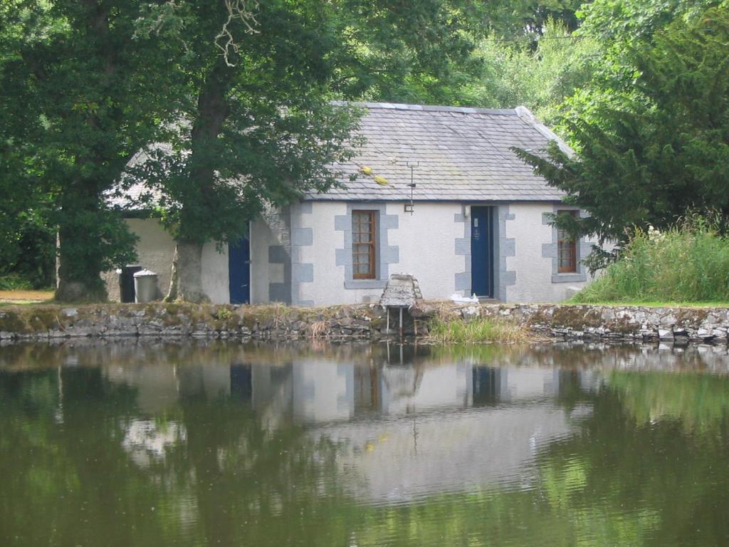 a house sitting next to a body of water at Pond Cottage in Covington