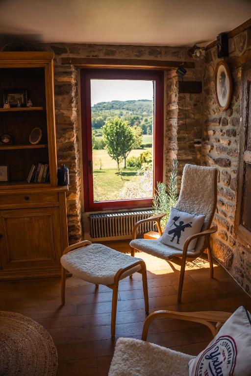 un salon avec une chaise et une fenêtre dans l'établissement Lodge de La Vallée, à Saint-Rémy