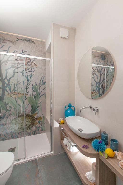 a bathroom with a shower and a toilet and a sink at Dimora Nesea in Cozze