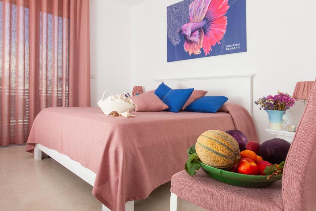 a bedroom with two beds and a bowl of fruit at Dimora Nesea in Cozze