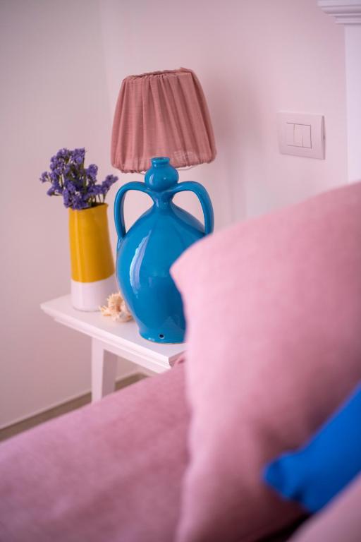 a blue vase sitting on a table with a lamp at Dimora Nesea in Cozze