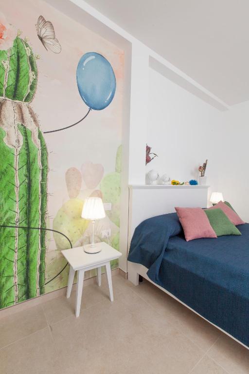 a bedroom with a bed and a blue balloon on the wall at Dimora Nesea in Cozze