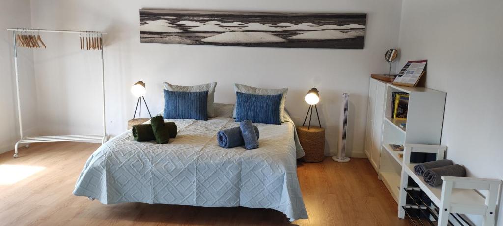 a bedroom with a bed with blue pillows at Loft Casa Burgao in Caleta de Caballo