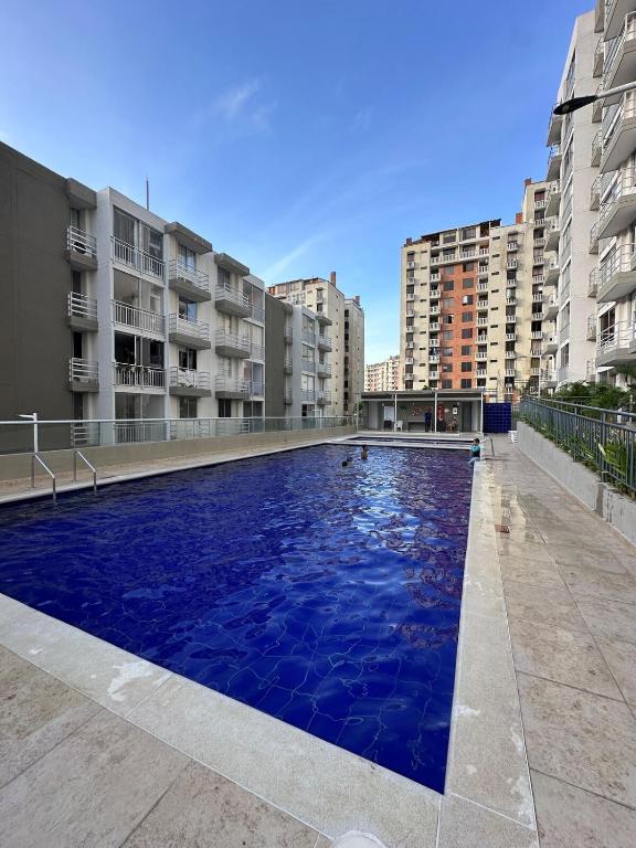 a large swimming pool in a city with buildings at Comfortable 2 bedroom apartment with pool in Miramar in Barranquilla