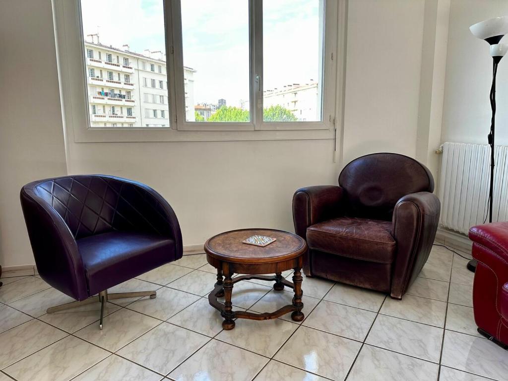 un salon avec deux chaises et une table dans l'établissement La tour d'ivoir, à Toulon