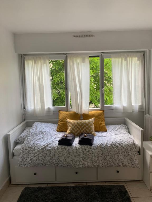 une chambre avec un lit avec deux chaussures dessus dans l'établissement Studio lumineux Paris 20, à Paris
