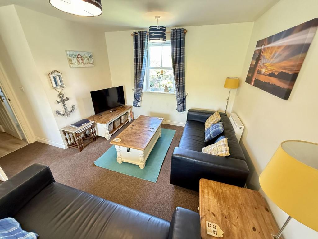 ein Wohnzimmer mit Sofa und Tisch in der Unterkunft Lighthouse Apartment in Filey