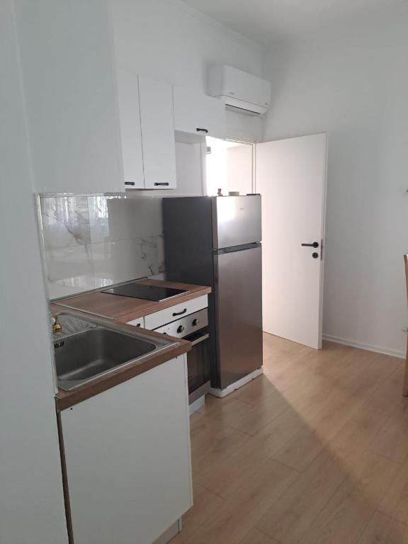 a kitchen with a stainless steel refrigerator and a sink at Vila Konti 42 in Durrës