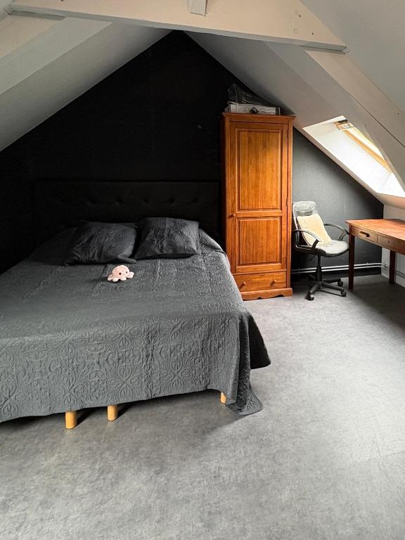 - une chambre avec un lit, une armoire et une chaise dans l'établissement Doryan, à Sargé-lès-Le Mans