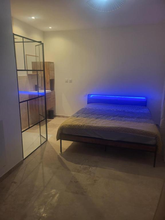 - une chambre dotée d'un lit avec des lumières bleues dans l'établissement T2 jardin neuf, à Béziers