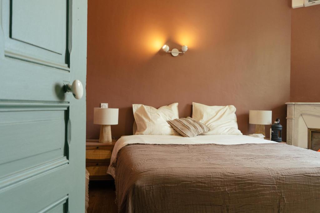 une chambre avec un grand lit avec des oreillers blancs dans l'établissement La Maison Léon, à Biscarrosse