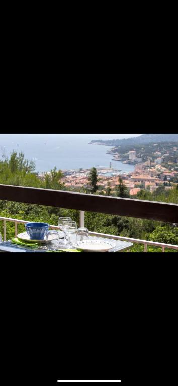 une table sur un balcon avec vue sur une ville dans l'établissement Cassis vue mer, à La Celle-sous-Gouzon