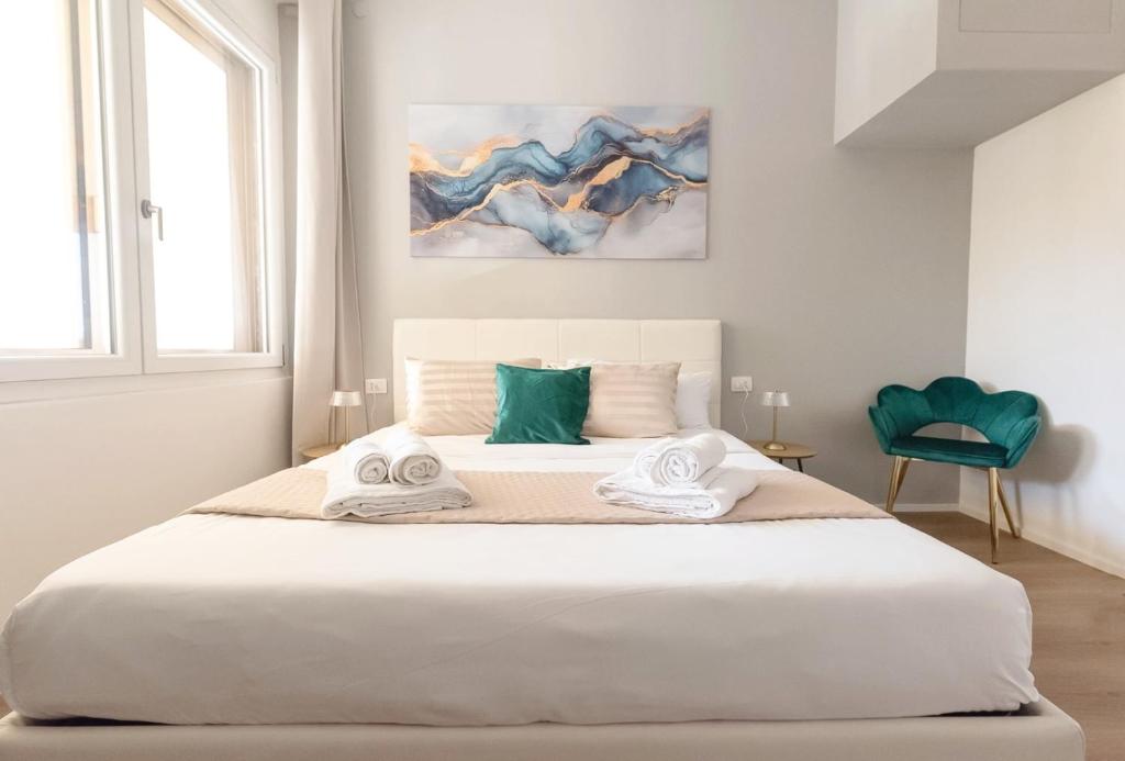 a bedroom with a large white bed with towels on it at Regina House al centro di Cagliari in Cagliari