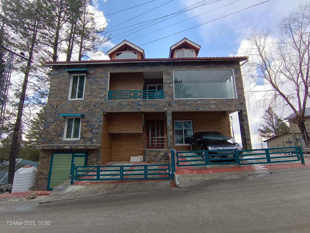 a house with a car parked in front of it at Sangha Cottage in Abbottābād