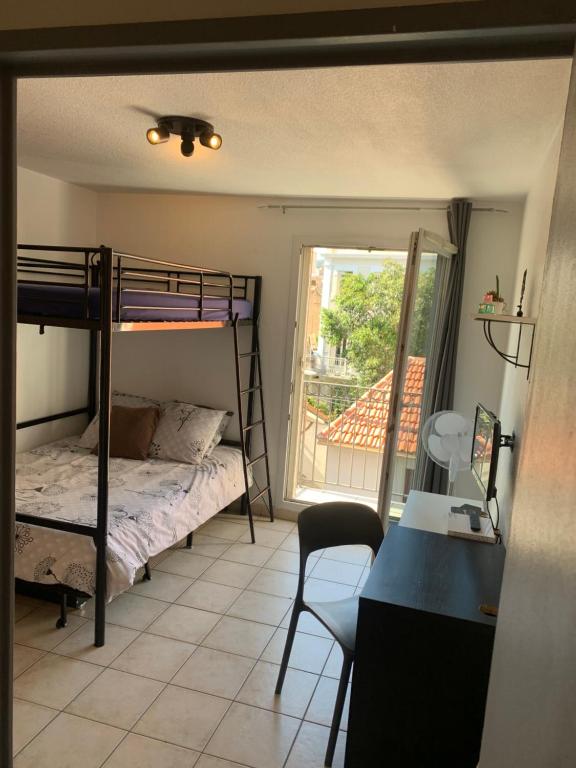 - une chambre avec des lits superposés, un bureau et une fenêtre dans l'établissement Raphael 20, à Toulon