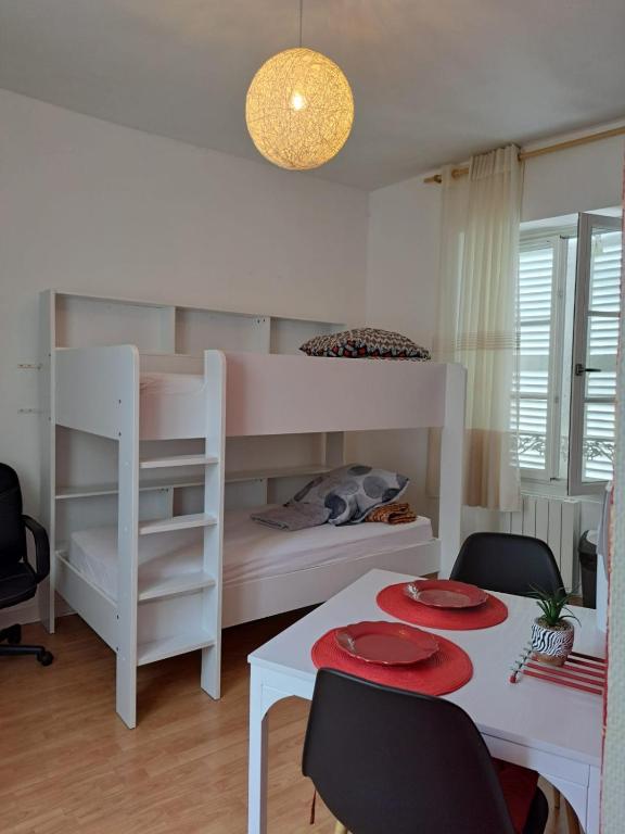 - une chambre avec des lits superposés, une table et des chaises dans l'établissement Studio confortable centre ville Poitiers, à Poitiers