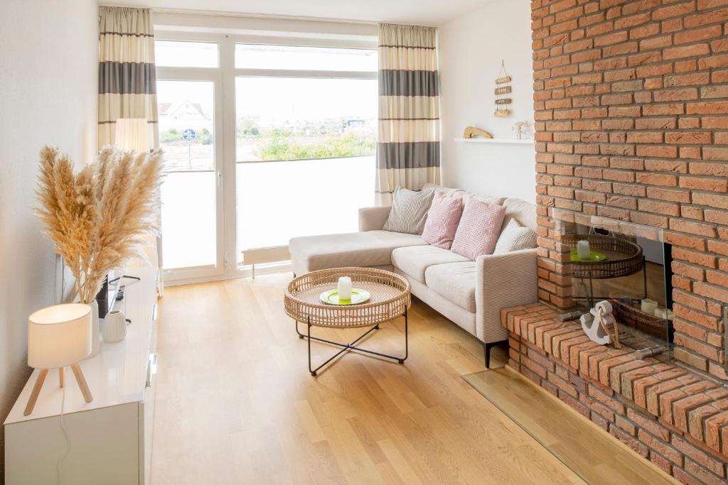 朗格奥'Wellenrauschen'的客厅设有砖砌壁炉和沙发。