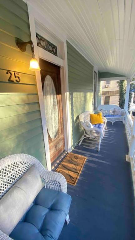 a porch with two wicker chairs on a house at Cricket Cottage in Eureka Springs