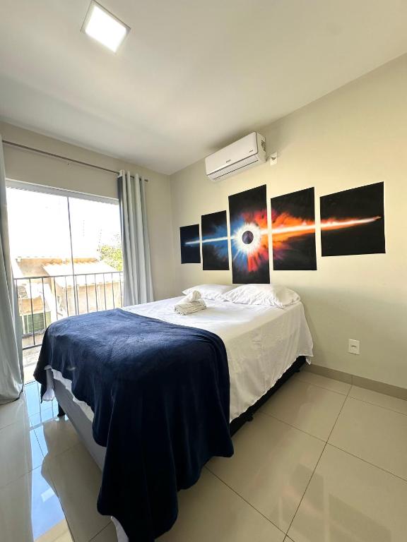 a bedroom with a bed with pictures on the wall at Flat Davisis 9 - Parada do Jalapão e Aeroporto in Palmas