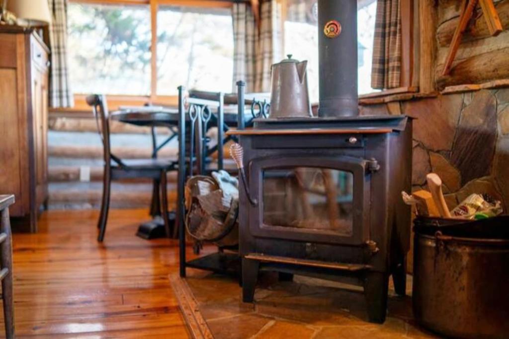 an old wood stove in a room with a table at Coyotes Rest Lake Lucerne 8 in Eureka Springs
