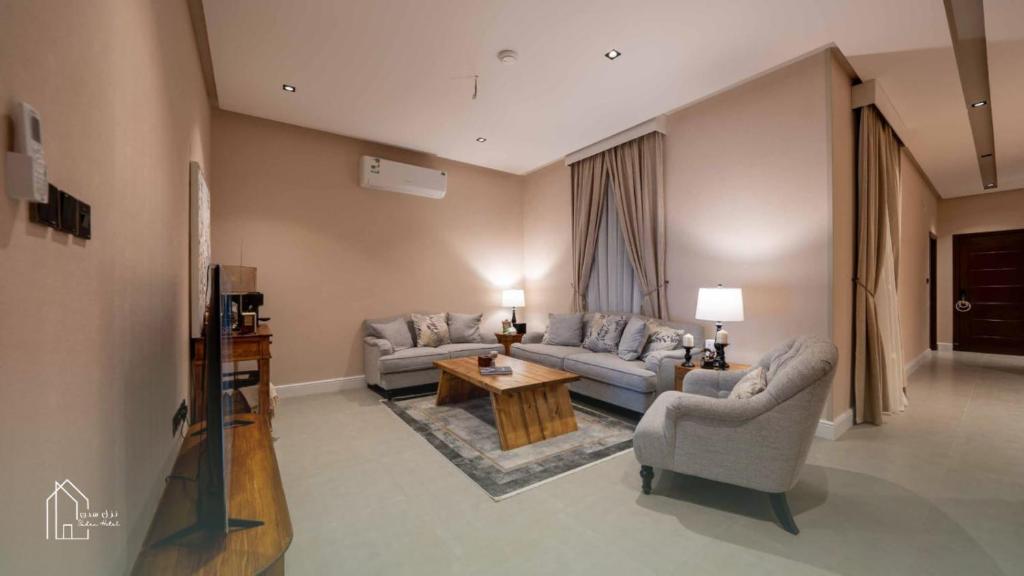 a living room with two couches and a table at نزل سدن in Quai