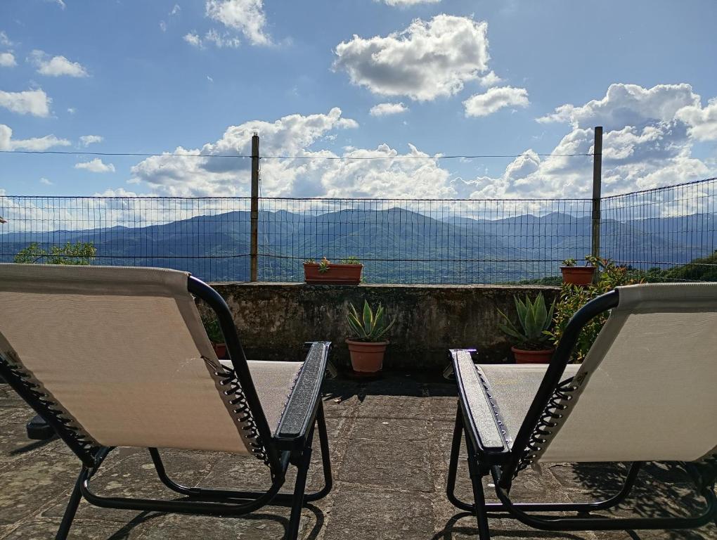 two chairs on a patio with a view of the mountains at La Romanina in Bagnone