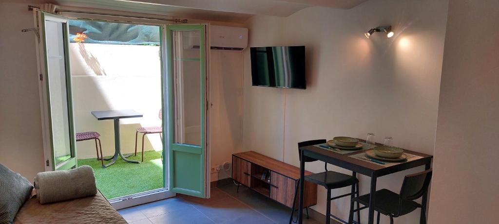 Una sala de estar con una mesa pequeña y una puerta corrediza de vidrio. en Studio Nice centre, en Niza